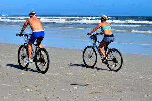 2 personnes à vélo sur la plage dans l'établissement suite arraial, à Arraial d'Ajuda