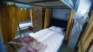 ein kleines Zimmer mit einem Bett und einem Spiegel in der Unterkunft Laxmi Dormitory in Vrindāvan