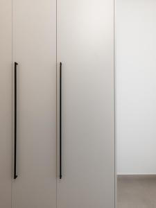 a group of four white doors with black handles at Cozy Apartment in Kalamaria, Thessaloniki in Thessaloniki