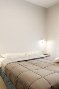 1 cama grande en un dormitorio con una pared blanca en Cozy Apartment in Kalamaria, Thessaloniki, en Tesalónica