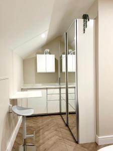 a dressing room with a glass partition and a stool at Attic Room in Citywest in Dublin