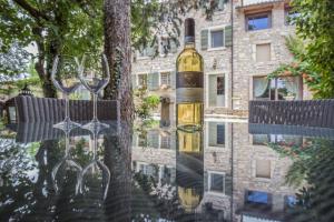 butelka wina wisząca na drzewie z kieliszkami do wina w obiekcie Antica Corte w mieście Soave