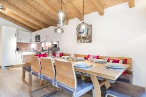 a dining room with a wooden table and chairs at Wasserfall Lodge Krimml in Krimml