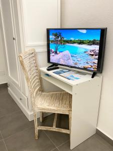 a computer desk with a television on top of it at Cala Reale Rooms Marinella in Marinella