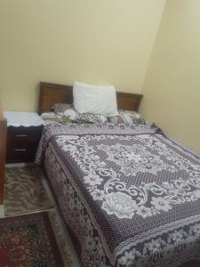 a bedroom with a bed with a blanket and a pillow at Kazpilkna Beach Neighborhoods in Hurghada