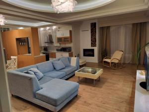 uma sala de estar com um sofá azul e uma mesa em Achilles Apartment em Nafplio