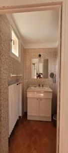 een badkamer met een witte wastafel en een spiegel bij Le Petit Mas Rouge in Saint-Rémy-de-Provence