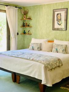 a large bed in a bedroom with green walls at KURALEMU Casa de Campo in Curacaví
