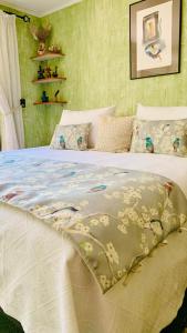 a bed with a white comforter with flowers on it at KURALEMU Casa de Campo in Curacaví