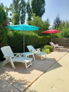 3 Stühle und 2 Sonnenschirme auf einer Terrasse in der Unterkunft La Méridienne - Gite Ceusette in Venterol