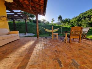 un patio con sofá, mesa y sillas en Sitio Carpir - conforto, charme e natureza a 2h de SP, en Paraibuna
