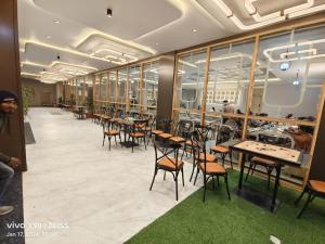 a row of tables and chairs in a restaurant at Hotel The Grand Khodiyar in Visnagar