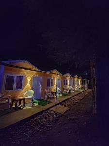 a row of houses with lights on them at night at Pandora Riverside Cafe & Stay in Kasol