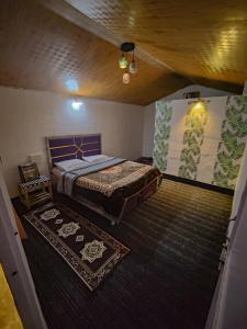 a bedroom with a large bed and a rug at Pandora Riverside Cafe & Stay in Kasol