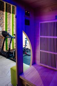 a purple room with a mirror and a gym at Belle View Apart Hotel in Turda