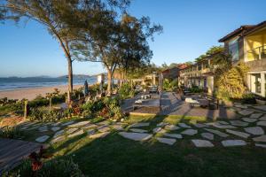 a walkway next to a beach with benches at Pousada dos Gravatás in Búzios