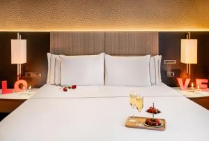 a large white bed with a tray of fruit on it at Meliá Paulista in São Paulo