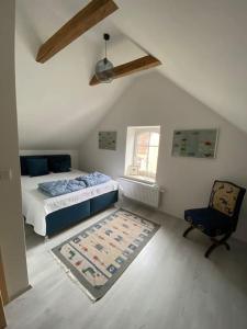 1 dormitorio con 1 cama, 1 silla y 1 alfombra en Entzückendes Häuschen, neu ren. en Groß-Siegharts