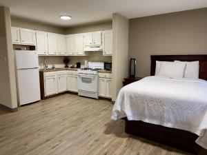 a bedroom with a bed and a kitchen with white cabinets at Wapiti Lodge in Durango