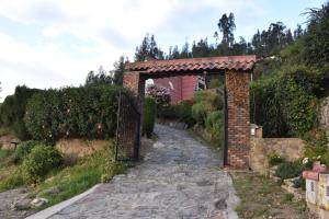 Zugang zu einem Garten mit Torbogen in der Unterkunft CHALET LOS PINOS in Duitama