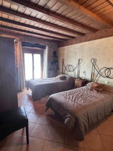 a bedroom with two beds and a window at Hotel rural Casa la Juana in Almarza