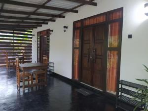 - une chambre avec une table, des chaises et une porte dans l'établissement Yashi's Place Sigiriya, à Sigirîya