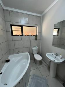 a bathroom with a tub and a toilet and a sink at Home@Micasa Unit 95 in Potchefstroom