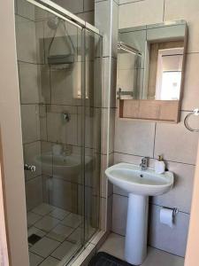 een badkamer met een glazen douche en een wastafel bij Home@Micasa Unit 95 in Potchefstroom