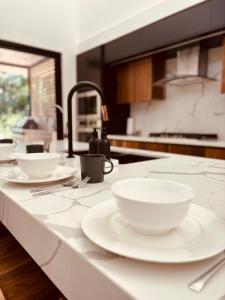- un comptoir de cuisine avec des bols blancs et des assiettes dans l'établissement Casa Emateena, à Uvita