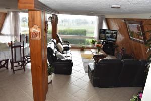 sala de estar con sofá y TV en CHALET LOS PINOS, en Duitama