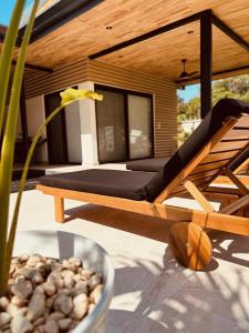un banc en bois installé sur une terrasse avec une plante dans l'établissement Casa Emateena, à Uvita