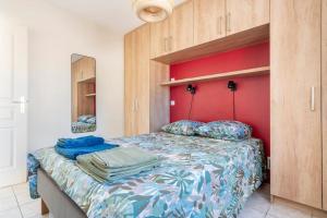 ein Schlafzimmer mit einem Bett mit einer roten Wand in der Unterkunft Jacques Cartier - ideal lake of Nantua in Montréal La Cluse