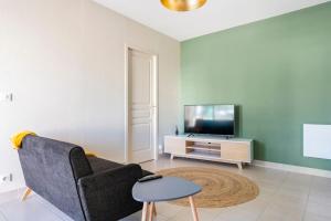ein Wohnzimmer mit einem Sofa und einem TV in der Unterkunft Jacques Cartier - ideal lake of Nantua in Montréal La Cluse