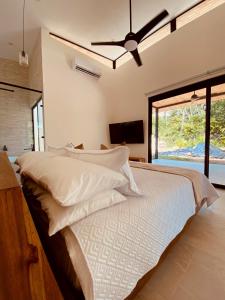 1 dormitorio con 1 cama grande y ventilador de techo en Casa Emateena, en Uvita