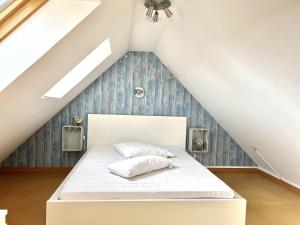 1 dormitorio con 1 cama en el ático en Dat Dörphuus, en Krummhörn