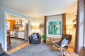 ein Wohnzimmer mit 2 Stühlen und eine Küche in der Unterkunft Cozy Portland Retreat Near Swan Island and Adidas HQ in Portland