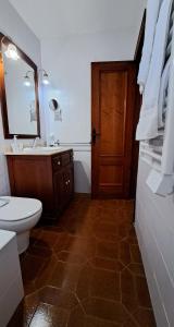 ein Badezimmer mit Toilette und Waschbecken und einer Tür in der Unterkunft La Elegida in Denia