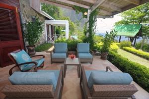 Authentic St, Lucian Experience at Prestigious 2-bed Villa - Colibri Cottage villa في سوفريير: فناء مع كراسي زرقاء وطاولة