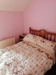 a bedroom with a bed with a floral comforter at 2 Rhys Terrace in Machynlleth