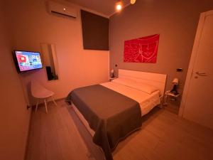 Schlafzimmer mit einem Bett und einem Flachbild-TV in der Unterkunft Home Serpico in Scisciano