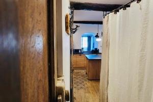 a hallway with a kitchen with a sink and a shower curtain at Merveille de loft vue mer Citadelle de Bonifacio in Bonifacio