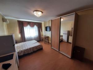 ein Hotelzimmer mit einem Bett und einem Spiegel in der Unterkunft Guest House Montreal in Odessa