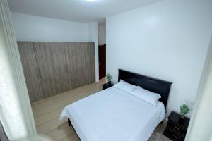 a bedroom with a white bed and a window at The Lake Victoria View Apartment in Wakiso