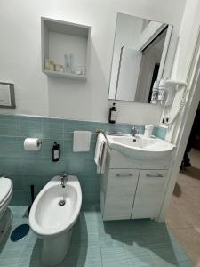 een badkamer met een wastafel, een toilet en een spiegel bij Home Serpico in Scisciano