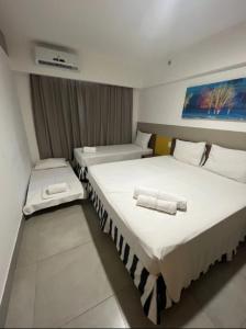 Olímpia Park Resort à 50m do Thermas dos Laranjais في أوليمبيا: سريرين في غرفة الفندق عليها مناشف