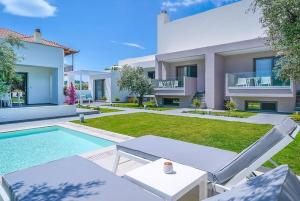une villa avec une piscine et une maison dans l'établissement Thassos OLIVIA RESORT, à Potos