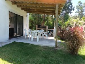 d'une terrasse avec une table et des chaises sous une pergola. dans l'établissement Casa muy luminosa , 2 d, à José Ignacio