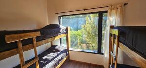 two bunk beds in a room with a window at Casa del Rio in Villa Meliquina +25 photos