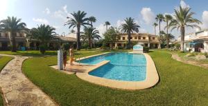 a person is standing next to a swimming pool at La Elegida in Denia