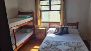 2 Etagenbetten in einem Zimmer mit Fenster in der Unterkunft POUSO DO BEIJA FLOR in Paraty